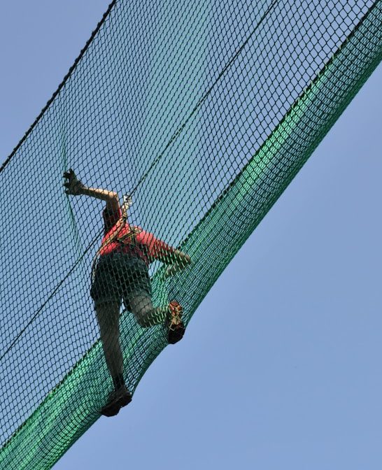 person crossing net bridge